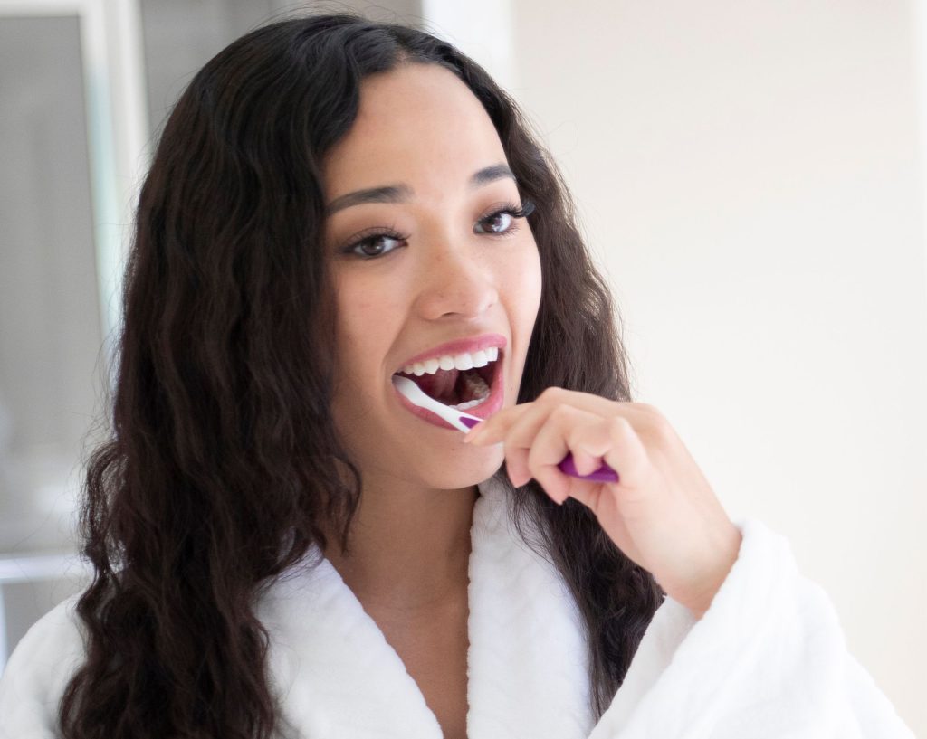 Young woman brushing her teeth